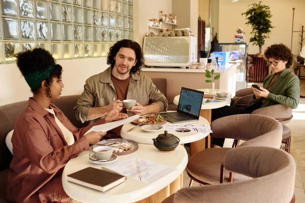 Female customer sitting at a coffee shop table, using a laptop connected to the internet, showcasing a cafe with a modern Wi-Fi management system