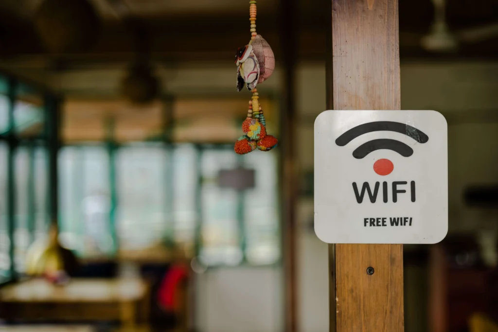 Free WiFi sign displayed in a cozy cafe setting, demonstrating AAA in Mi-Fi Management for public internet access points with traditional decor in background