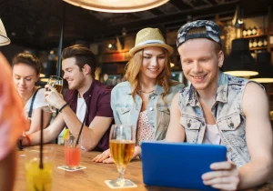 Young people at a cafe using a tablet to access the cafe's guest Wi-Fi