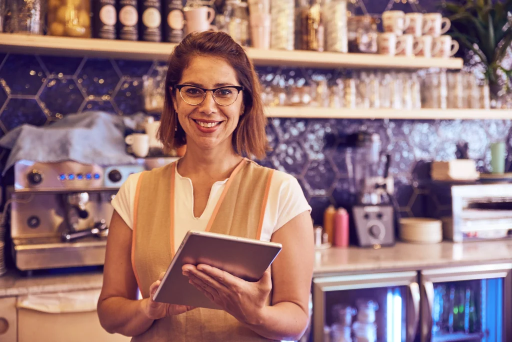 Café owner using a tablet to manage guest Wi-Fi, highlighting how businesses can stay GDPR compliant