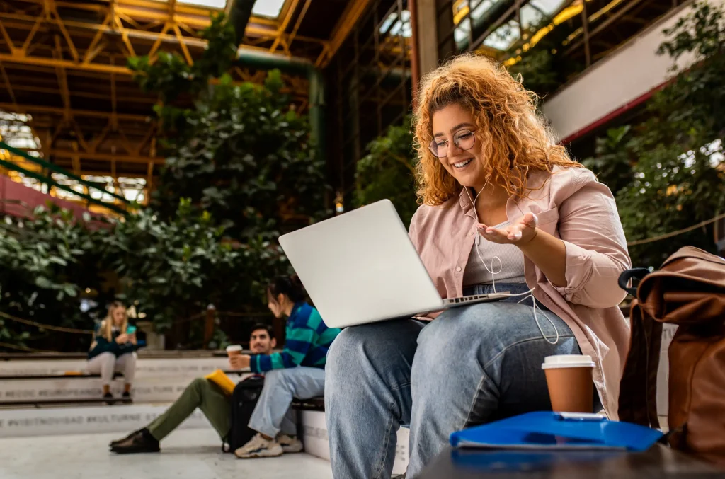 A student working on a laptop on a university campus, representing CCPA rules for collecting data through campus guest Wi-Fi