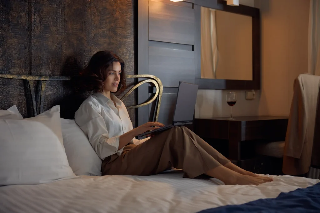 Hotel guest working online from a room using hotel Wi-Fi monetization tools for secure access