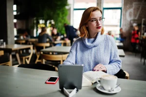 woman reading in cafe with coffee and tablet using wi-fi paid access
